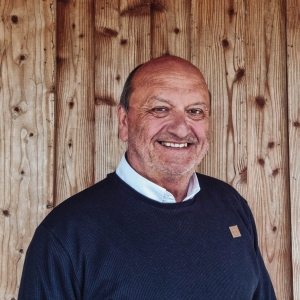 Portraitfoto von Peter Töbs vor einer Holzwand